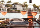 Three wine glasses with sparkling wine sitting at a waterside table