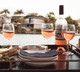 Three wine glasses with sparkling wine sitting at a waterside table